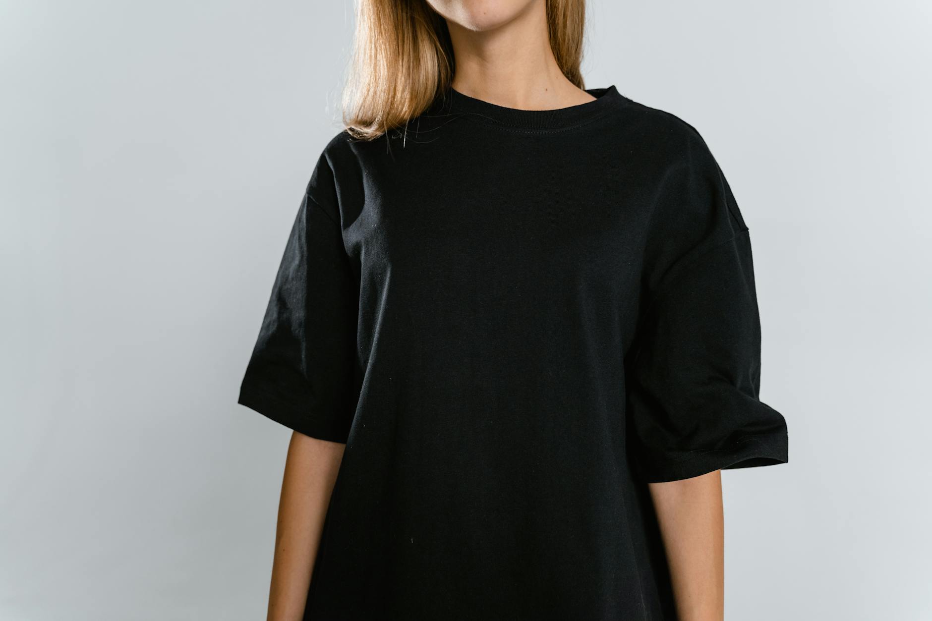 Vue de face d'une femme portant un t-shirt noir avec espace de copie sur fond blanc.